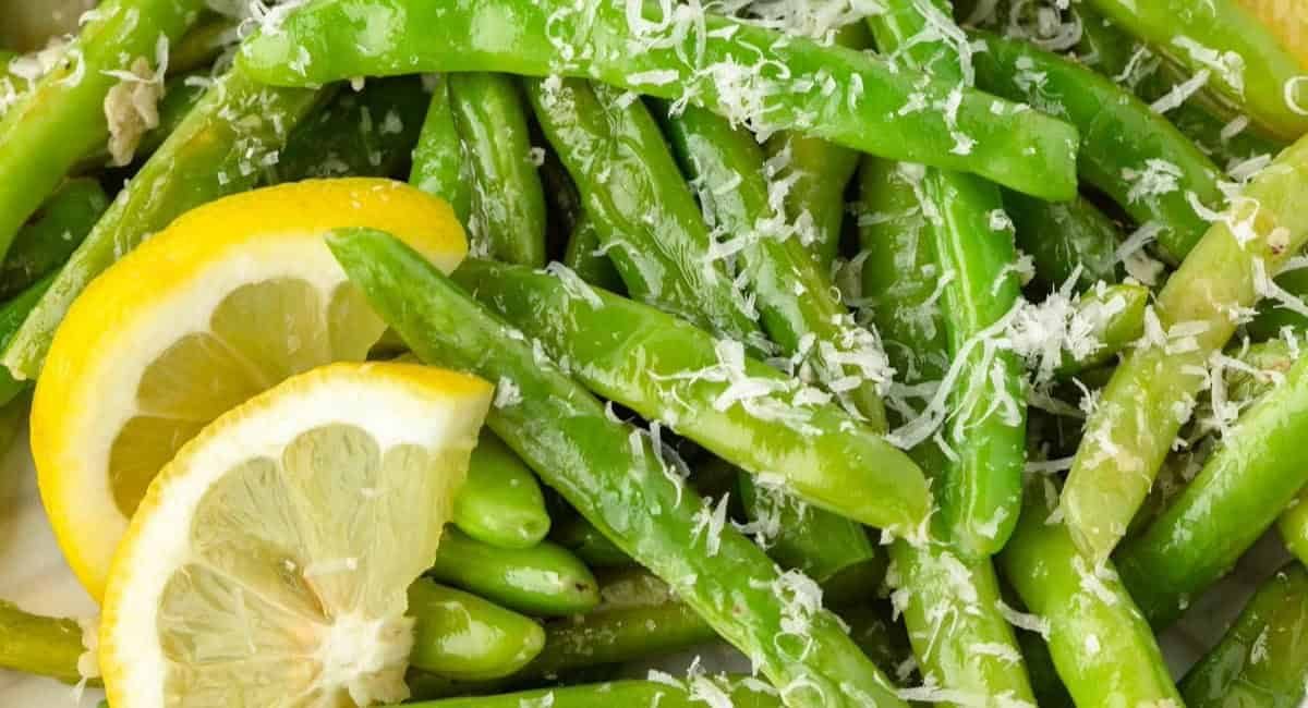 Overhead image of garlic parmesan green beans with lemon garnish.