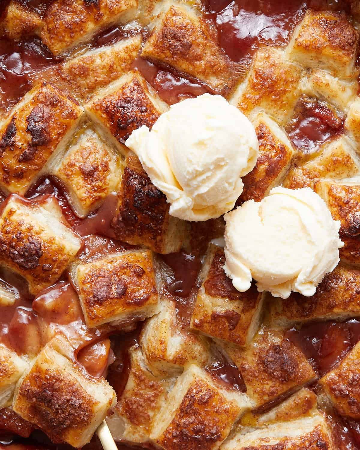 Up close image of peach cobbler with puff pastry.