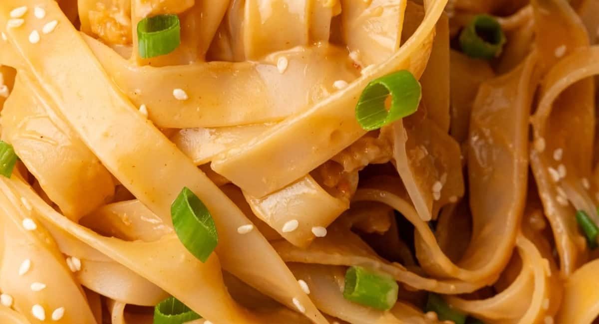 Up close image of peanut noodles with garnish.