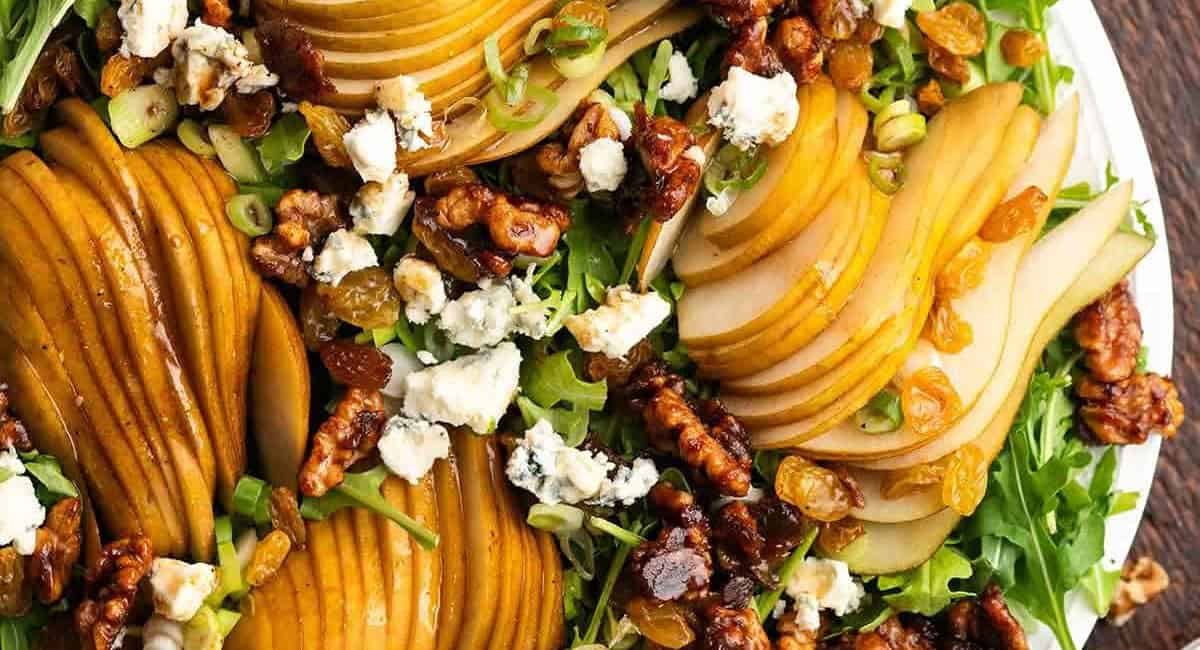 Overhead image of pear and rocket arugula salad with garnish.