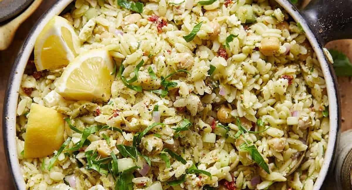 Overhead image of pesto orzo salad with garnish.