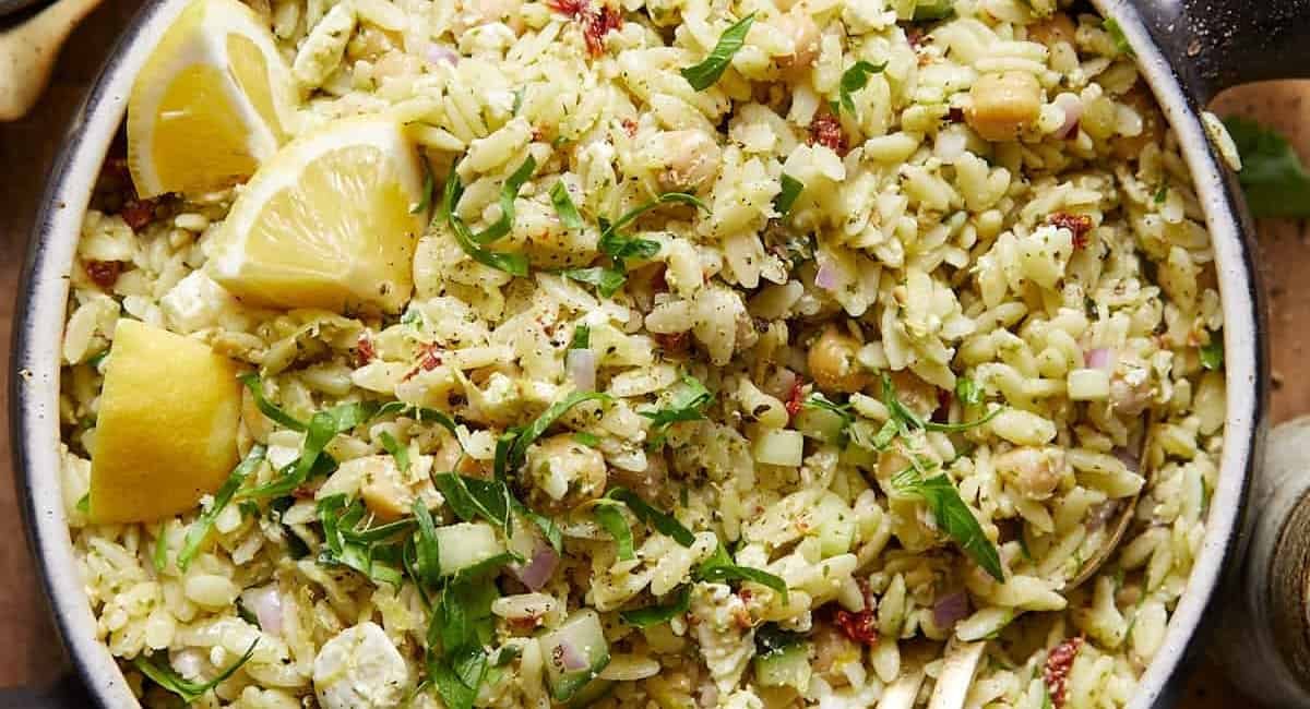 Overhead image of pesto orzo salad with garnish.