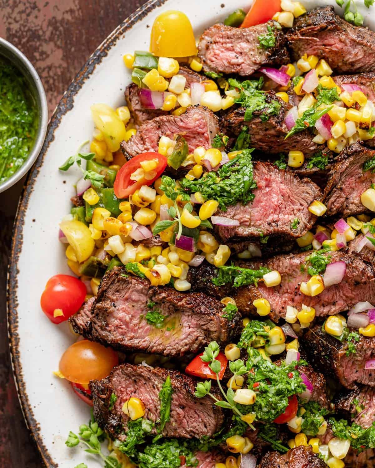 Picanha steak slices with corn salsa and chimichurri on top.