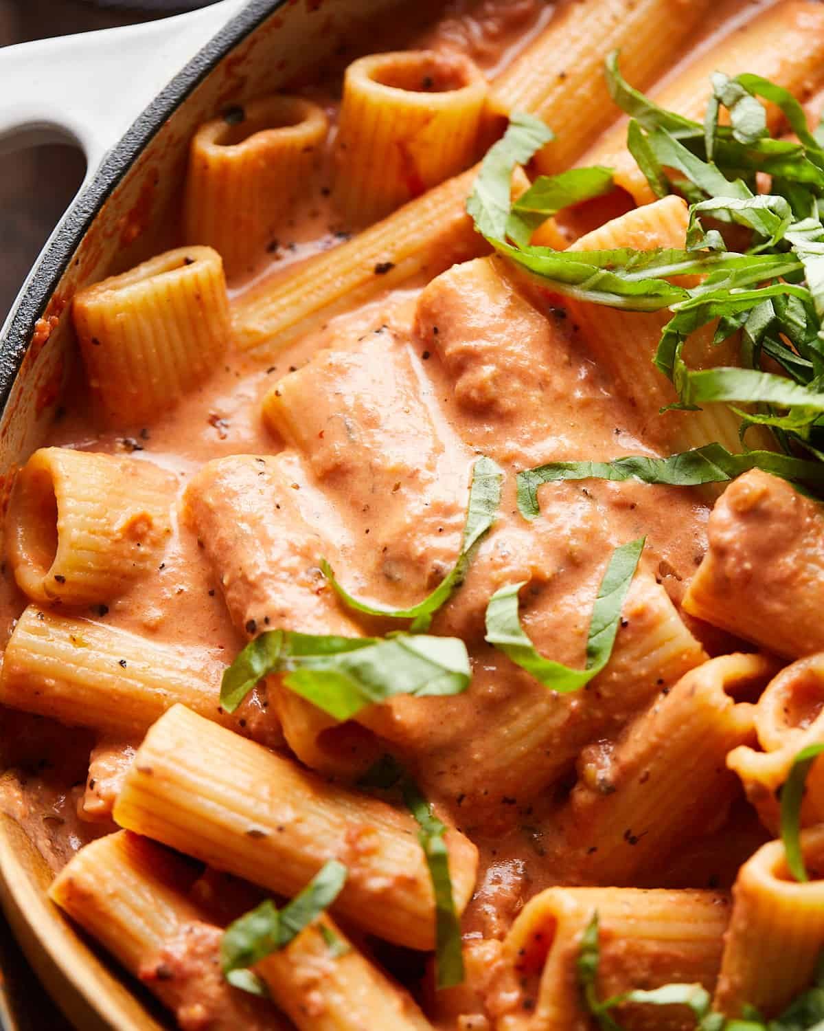 Up close image of pink sauce pasta with garnish.
