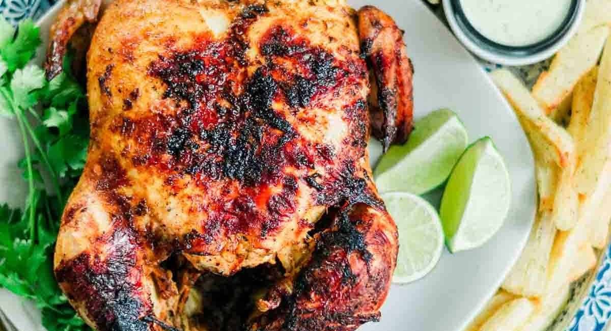 Overhead image of pollo asado with garnish and french fries as a side dish.