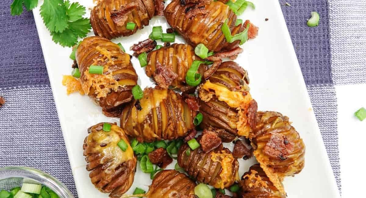 Overhead image of smoked hasselback potatoes on white platter.