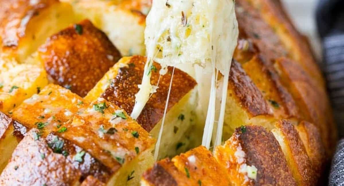 Up close image of cheesy pull apart bread with garnish.
