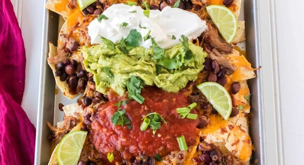 Overhead image of pulled pork nachos with garnish.