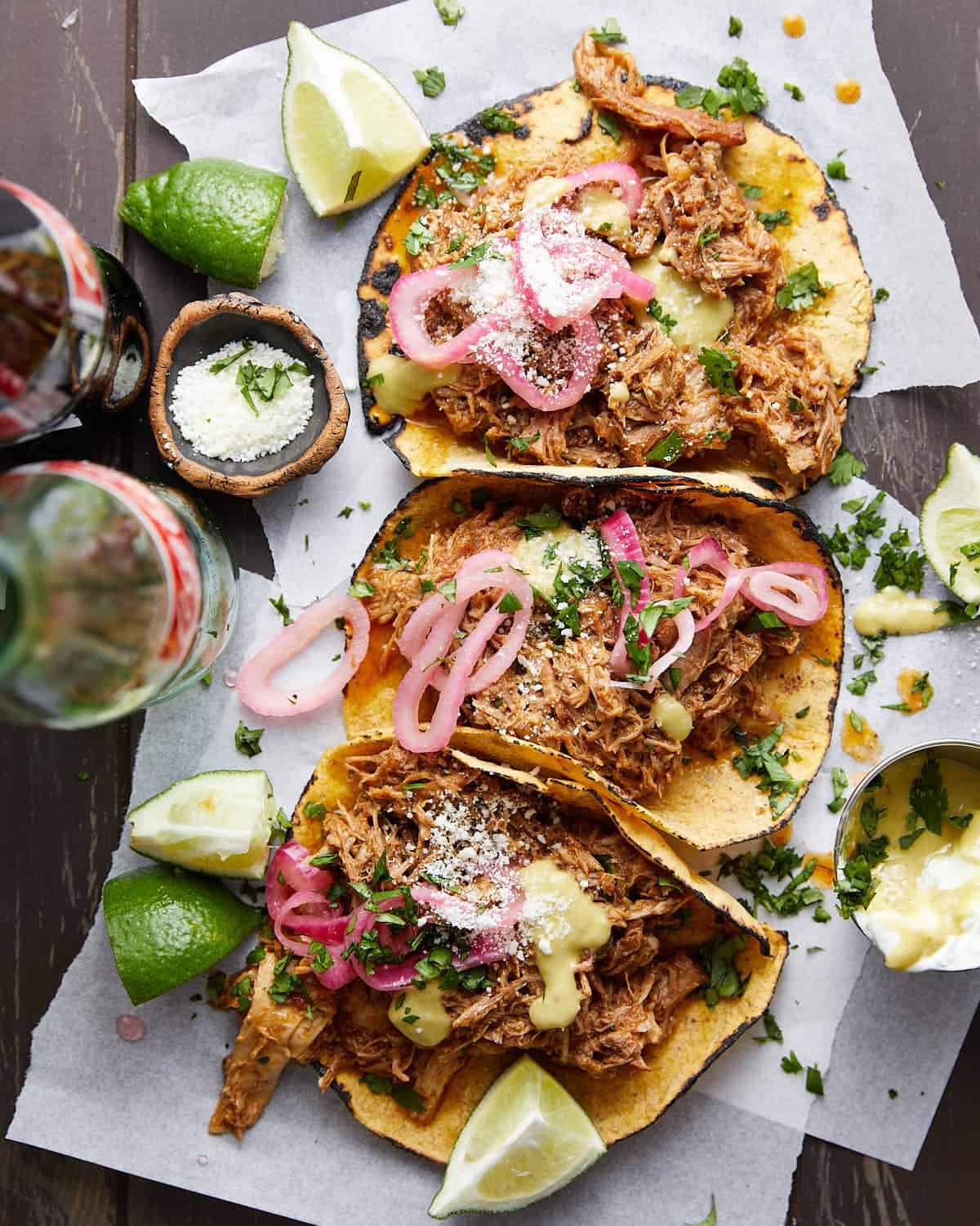 Overhead image of pulled pork street tacos with garnish.