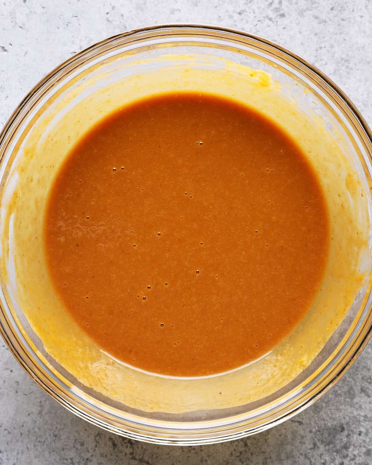 Smooth pumpkin mixture whisked with dark brown sugar, eggs, oil, sour cream, and vanilla.