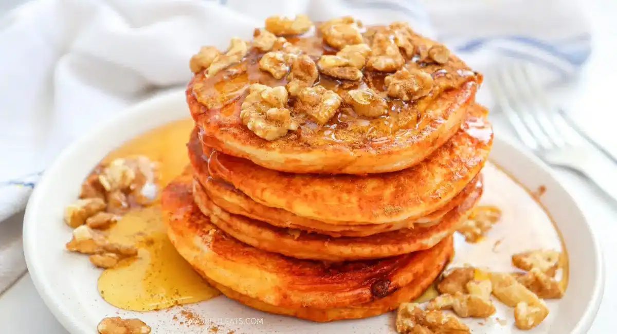 Up close image of pumpkin spice pancakes on white dish.
