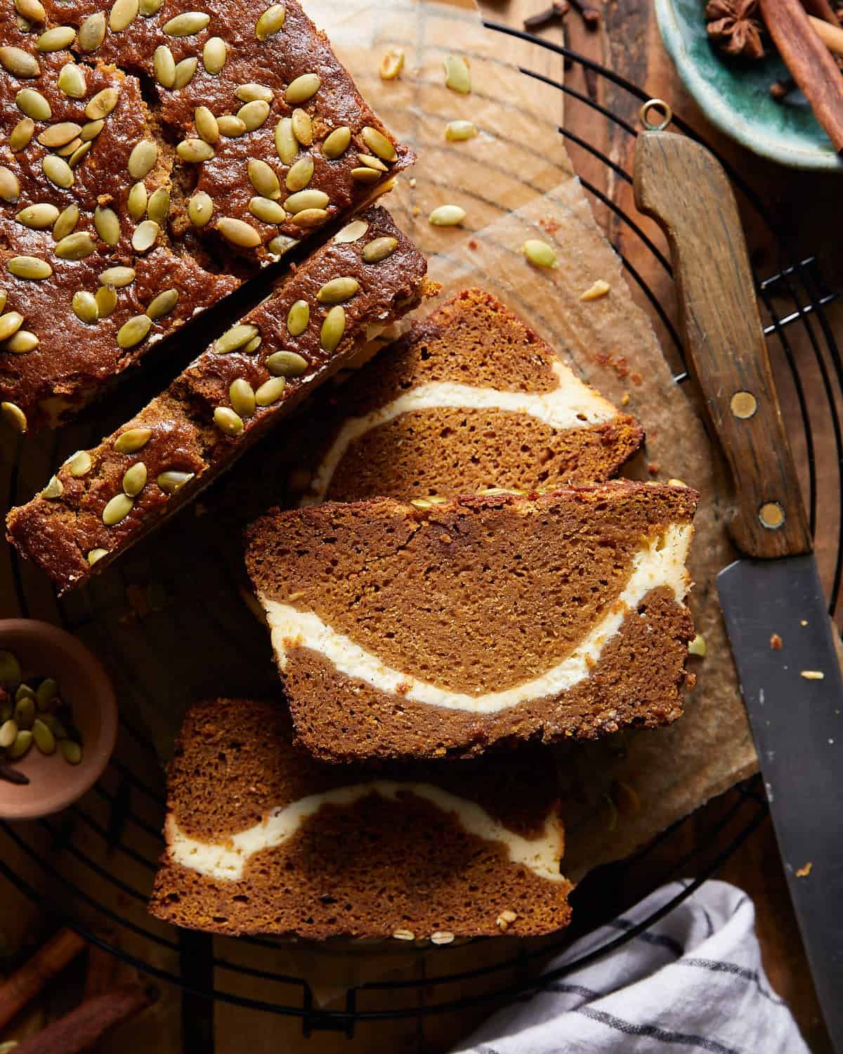 Pumpkin cream cheese bread sliced on a wire rack.