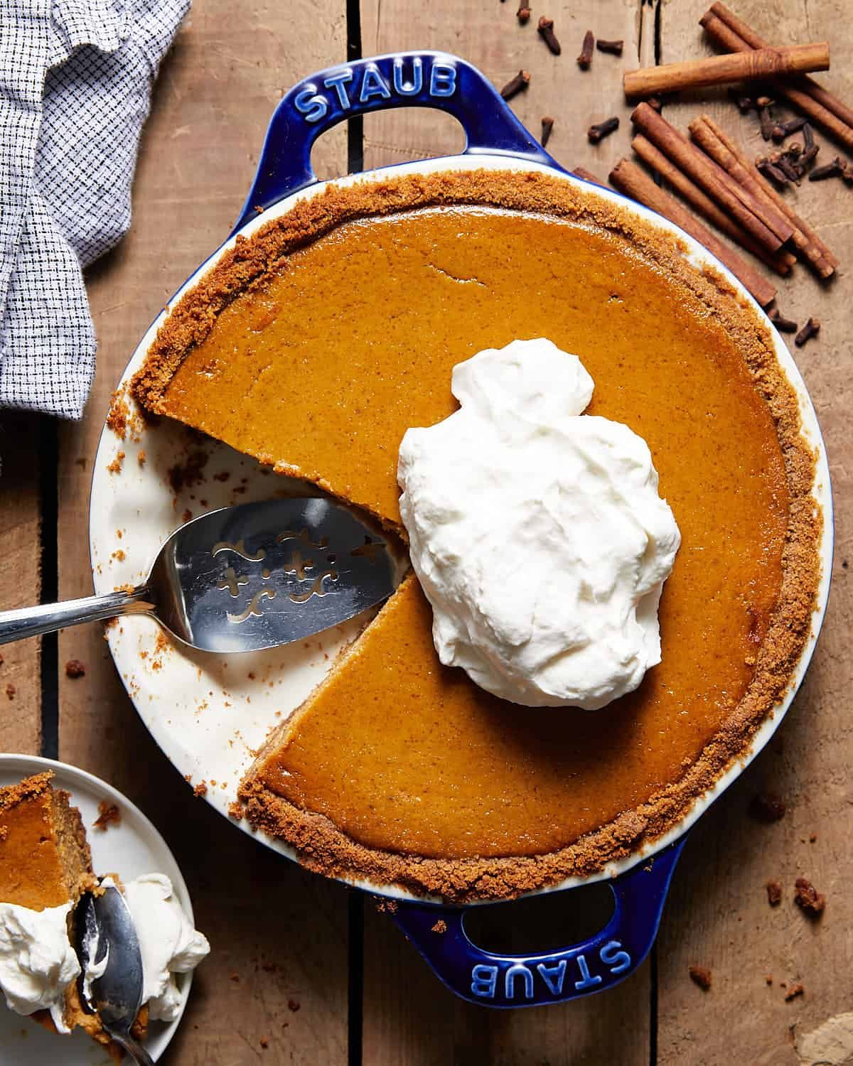 Pumpkin pie with graham cracker crust in a blue pie dish.