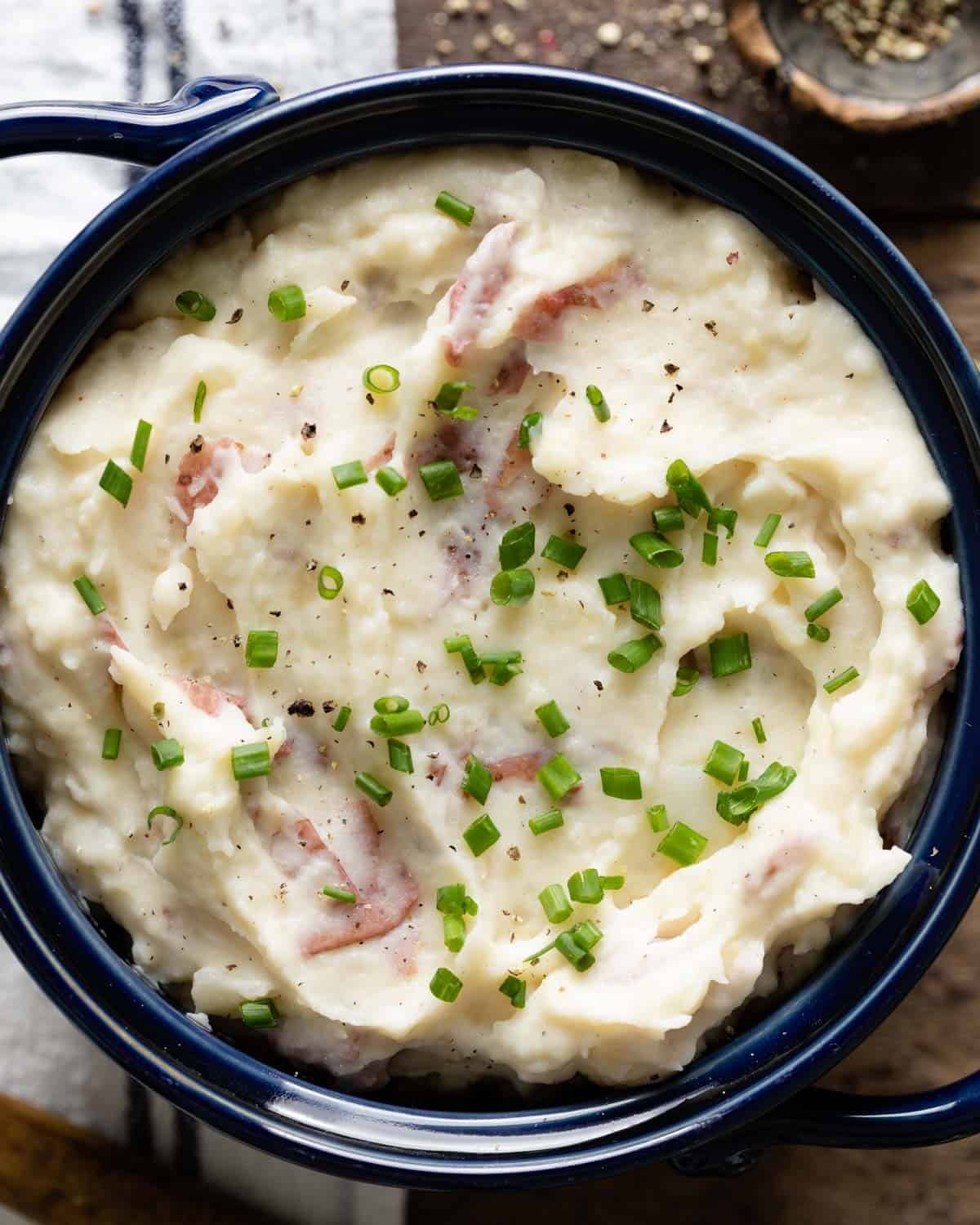 Mashed potatoes with chives and pepper on top.