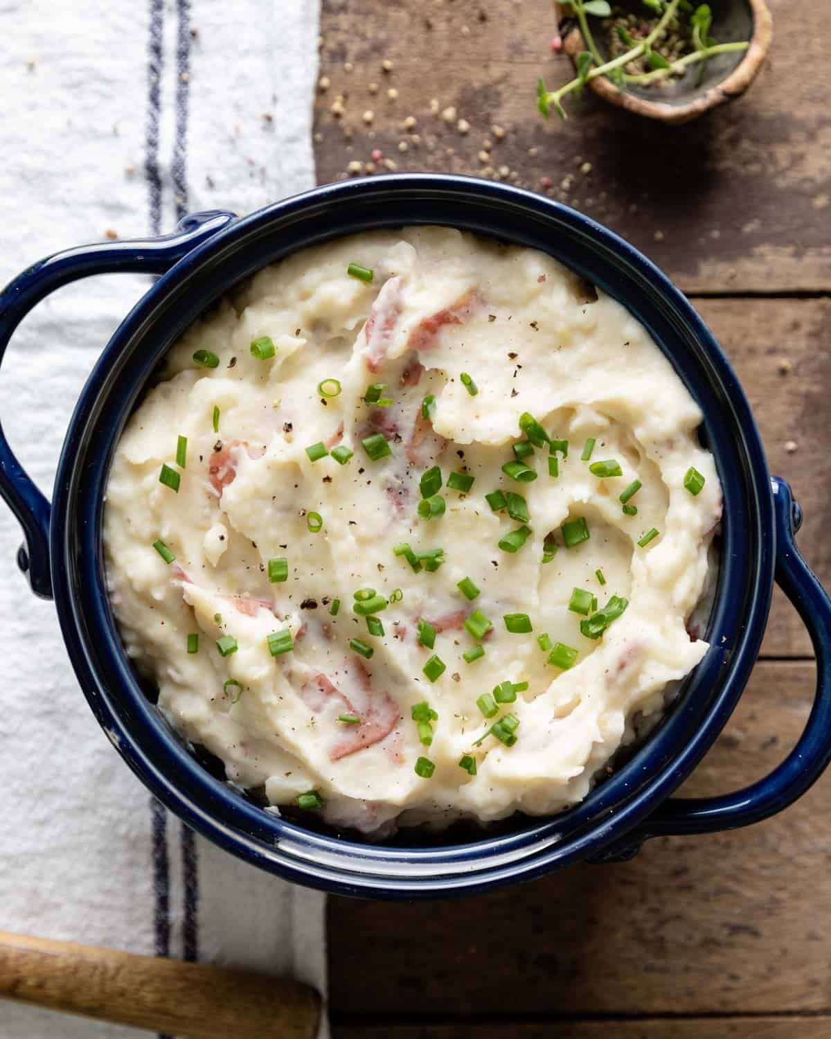 Mashed potatoes with red skin in a blue bowl.