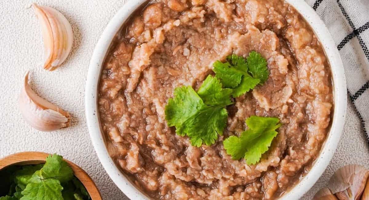 Overhead image of refried beans with garnish.