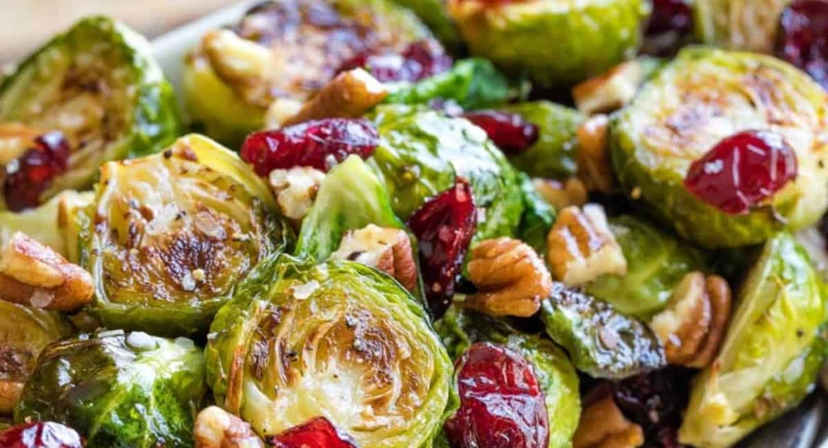 Up close image of roasted brussels sprouts with cranberries, pecans and hot honey.