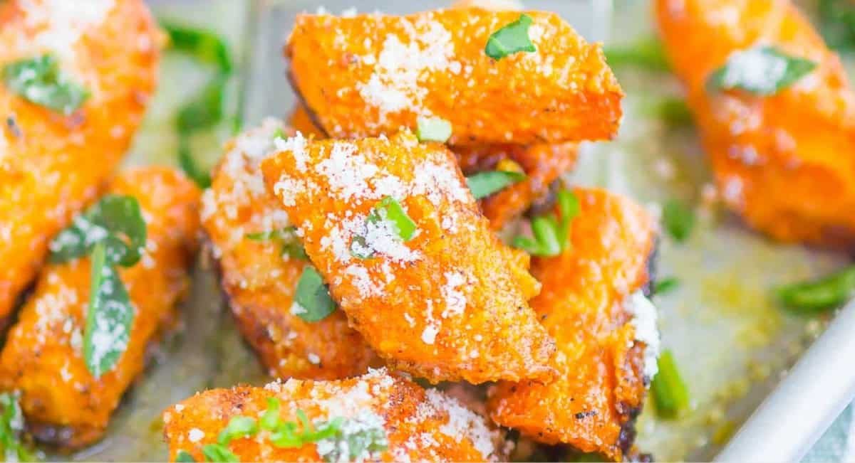 Overhead image of roasted garlic parmesan carrots with garnish.