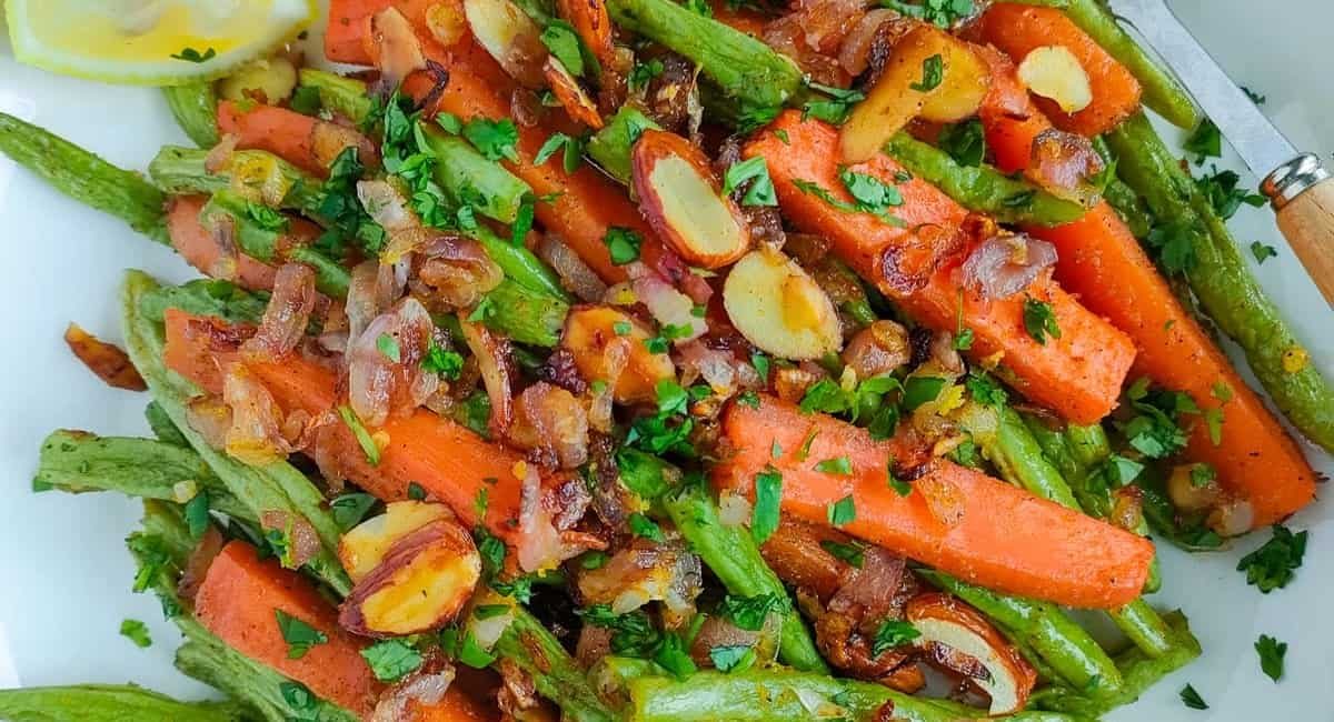 Overhead image of roasted green beans and carrots with almonds.