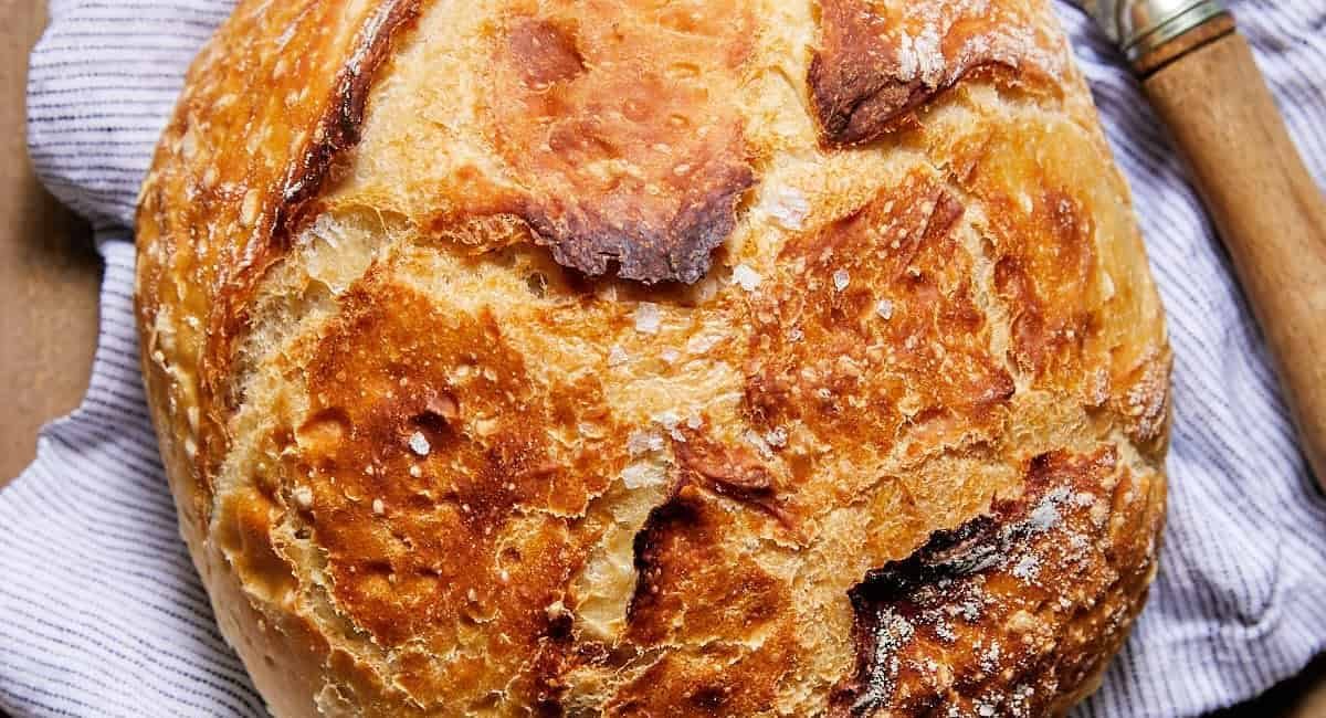 Overhead image of rustic bread on striped cloth.