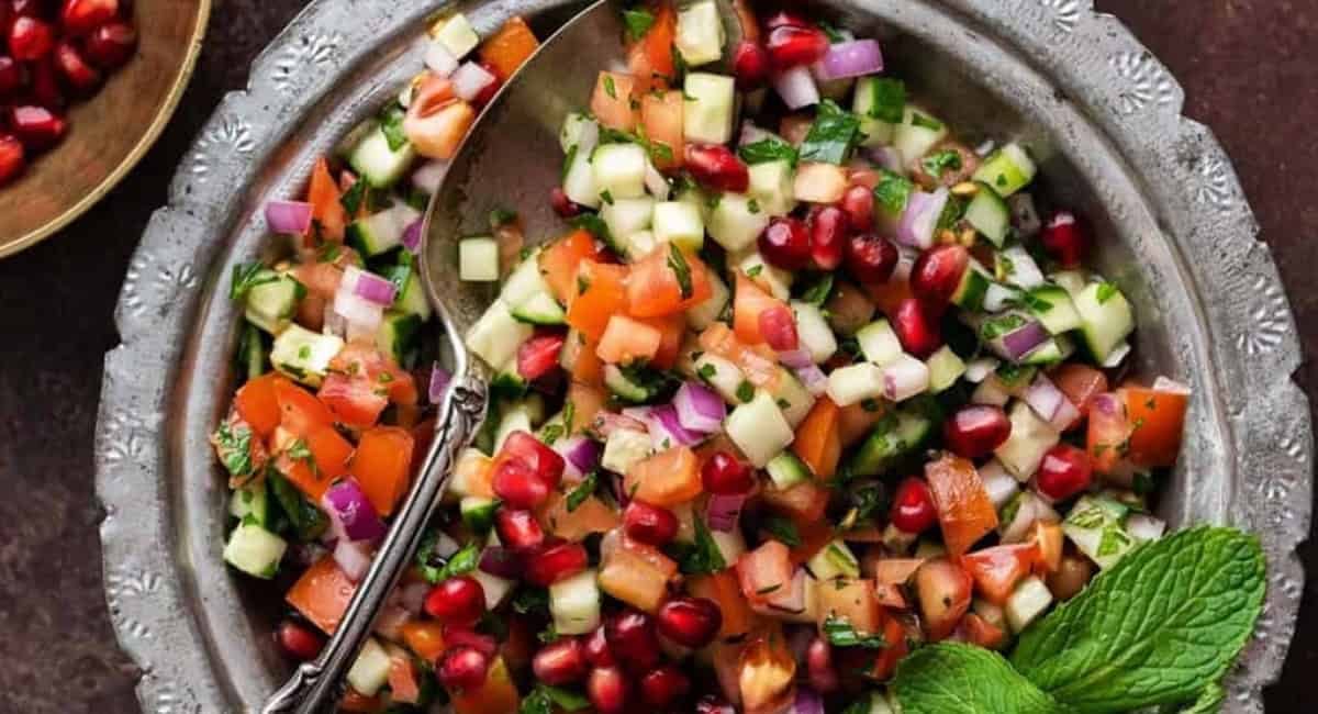Overhead image of Shirazi salad in silver bowl with spoon.