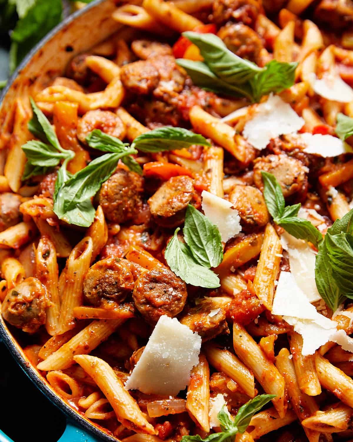 Italian sausage pasta and peppers in a blue pot.