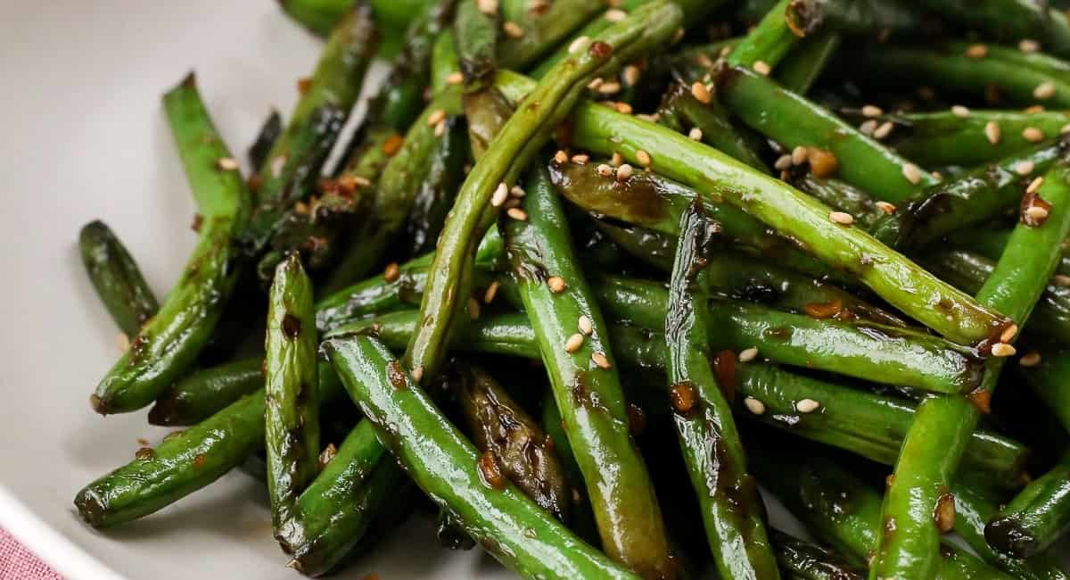 Overhead close up of sauteed green beans with soy sauce glaze.