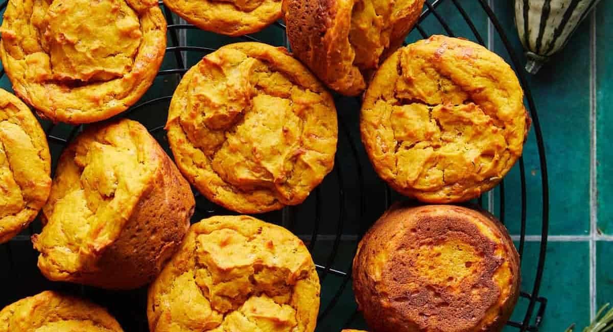 Overhead image of savory pumpkin muffins with parmesan & herbs on wire rack.