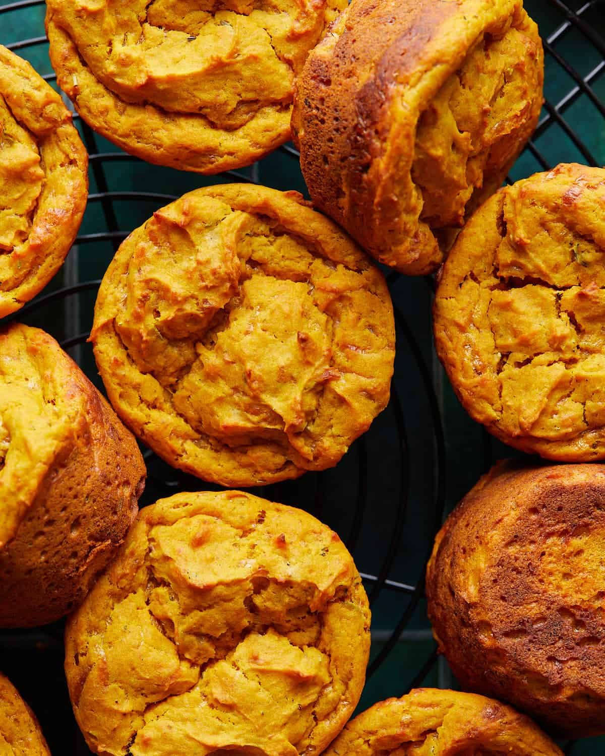 Up close image of savory pumpkin muffins on black wire rack.