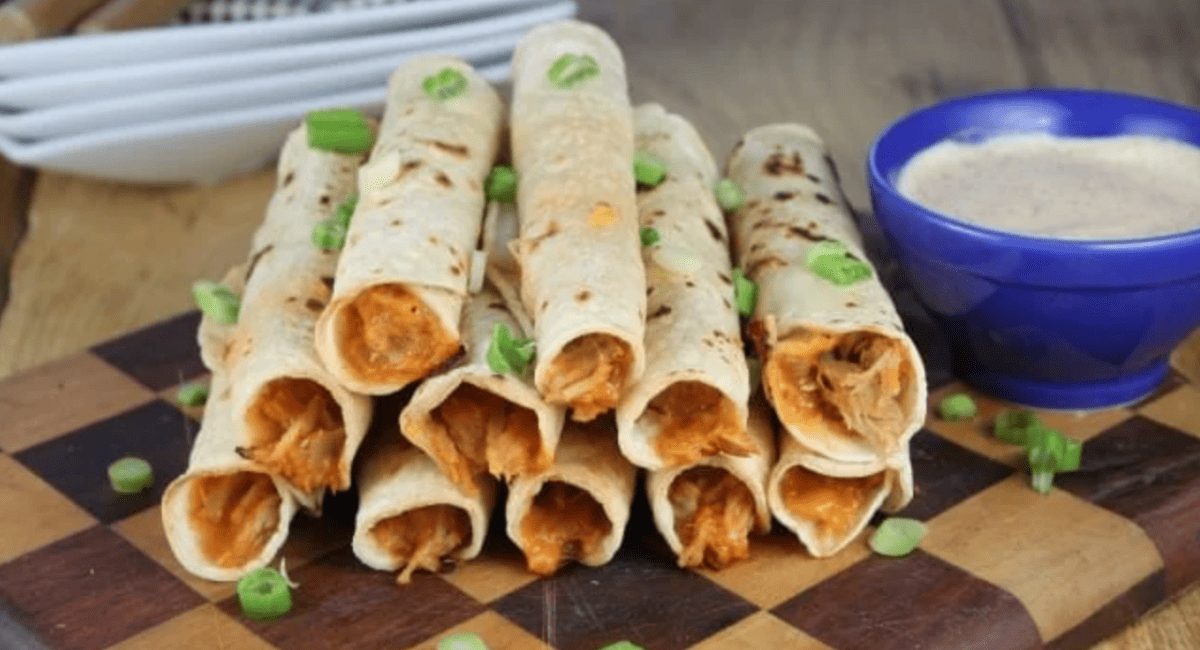 Up close image of cheesy pulled pork taquitos.