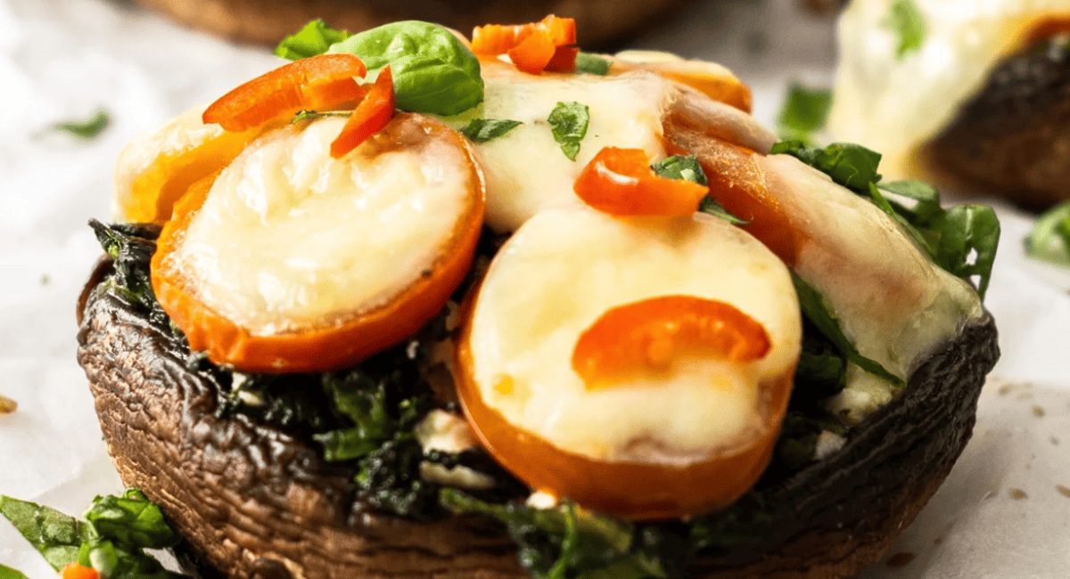 Up close image of spinach and mozzarella stuffed mushrooms.