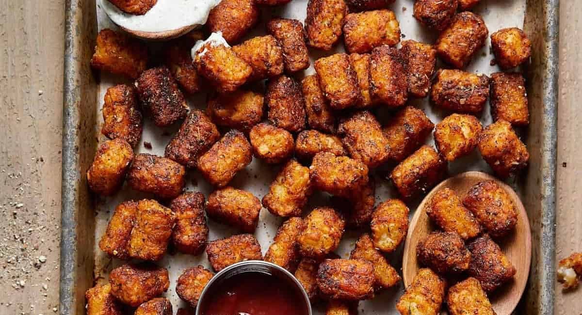 Overhead image of seasoned tater tots on baking sheet.
