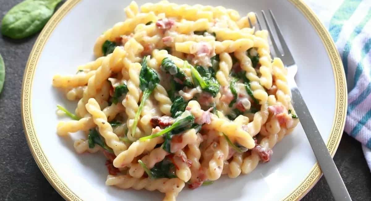 Overhead image of gemelli pasta with spinach.