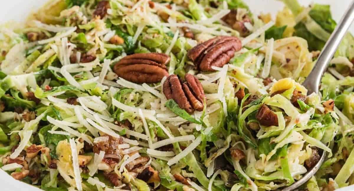 Overhead image of shaved vrussels sprouts and parmesan salad with silver spoon.