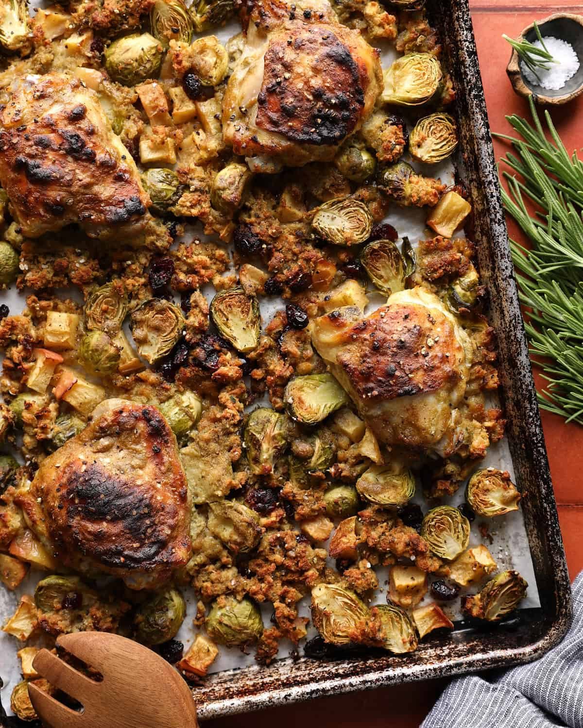 Sheet pan chicken and stuffing with browned maple Dijon thighs, Brussels sprouts, apples, and cranberries.