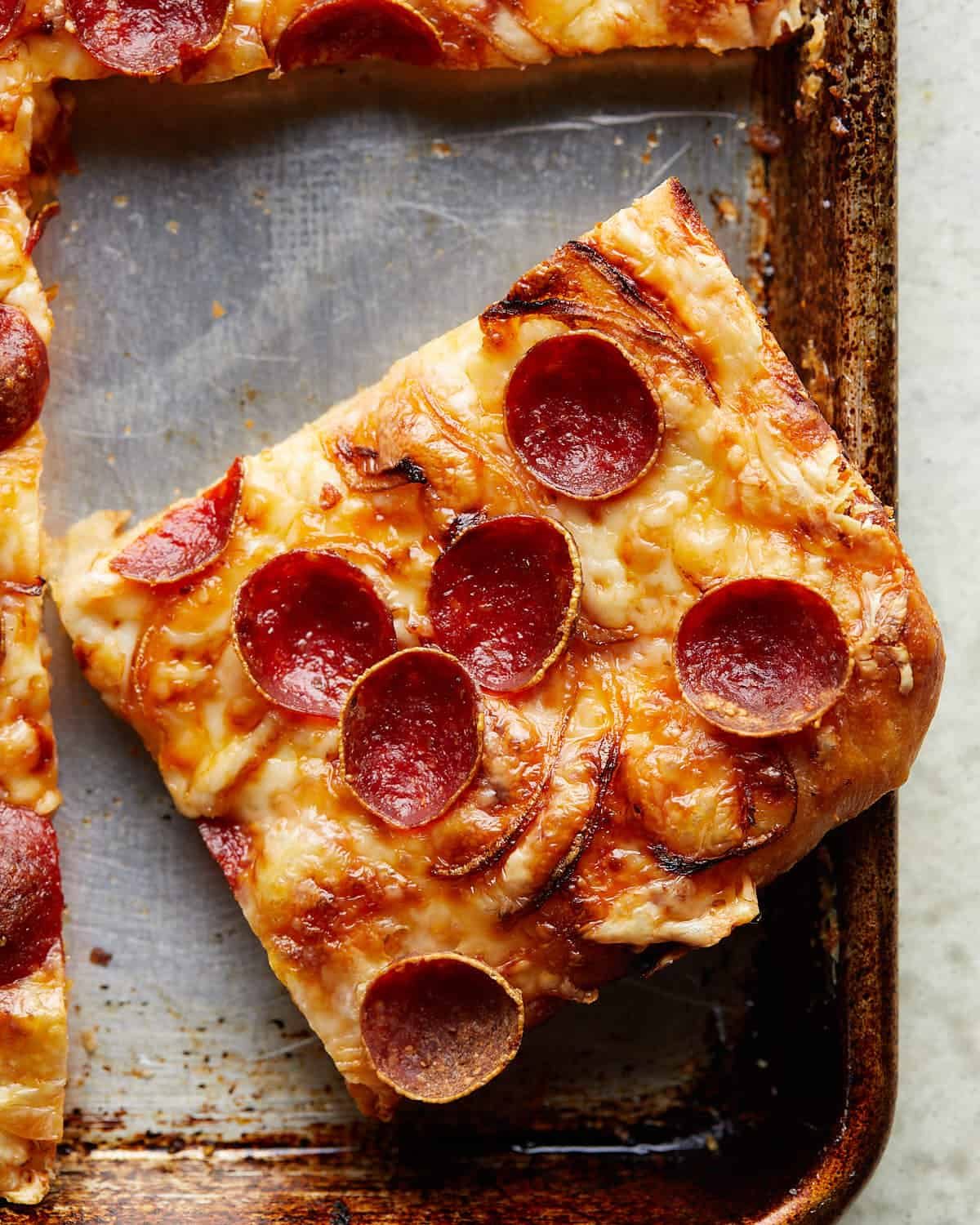 Up close image of crispy pepperoni sheet pan pizza.