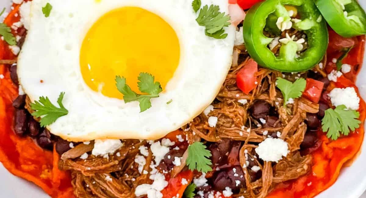 Overhead image of shredded beef red chilaquiles.