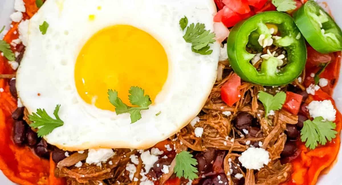 Overhead image of shredded beef red chilaquiles.