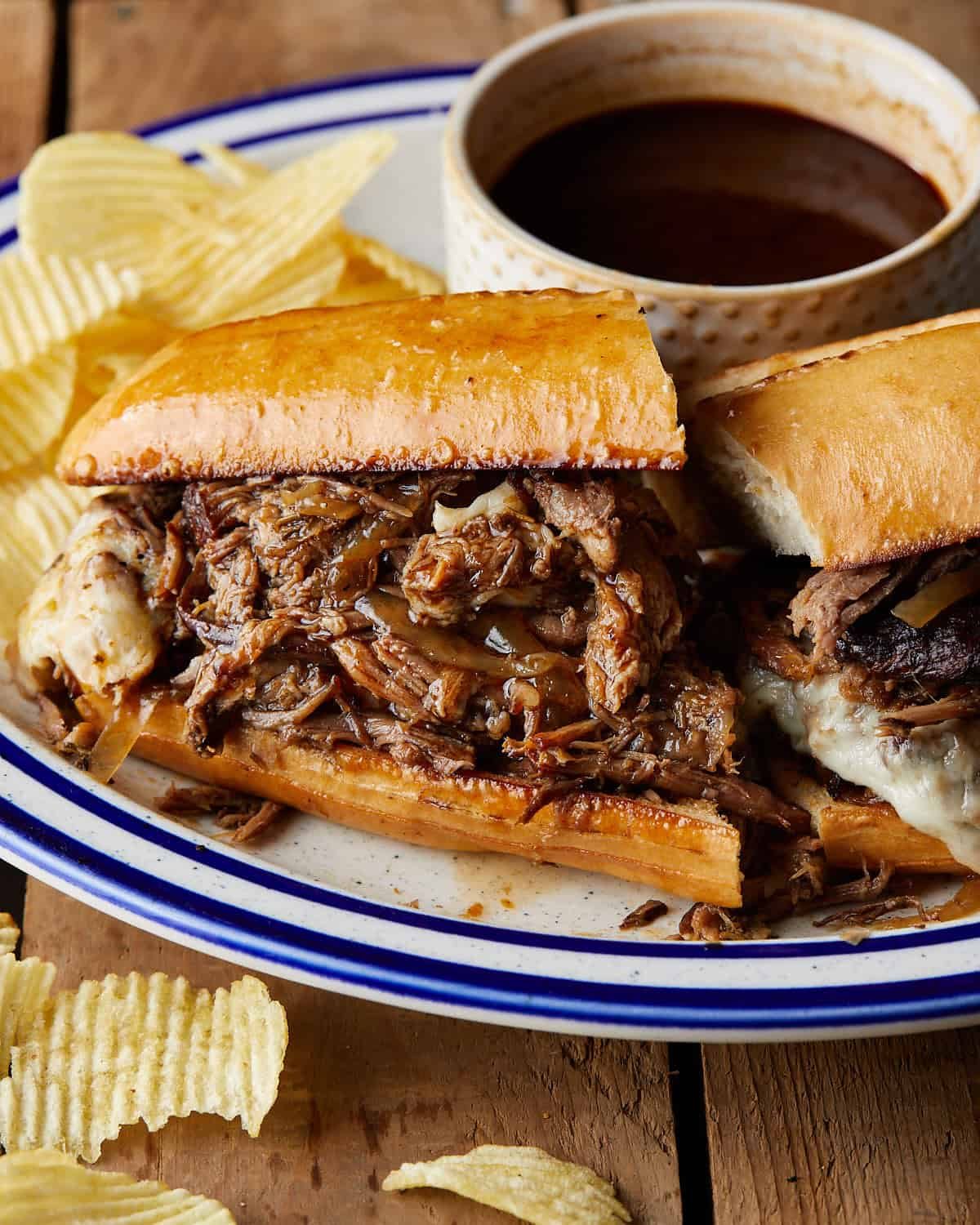 Side profile of french dip sandwiches with au jus.