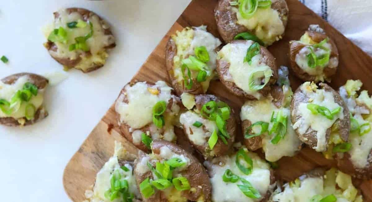 Overhead image of mashed potatoes with cheese and garnish.