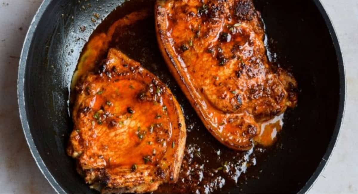 Overhead image of paprika butter pork chops with garnish.
