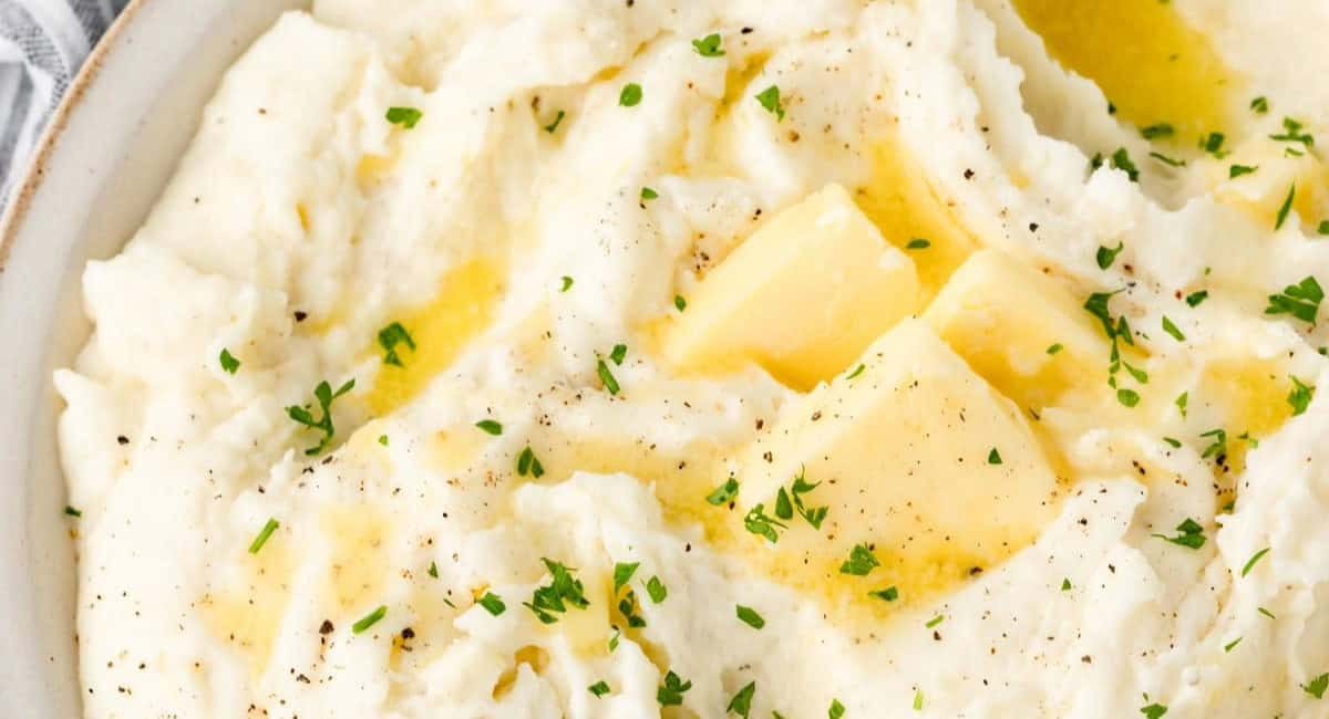 Overhead image of sour cream mashed potatoes with garnish.
