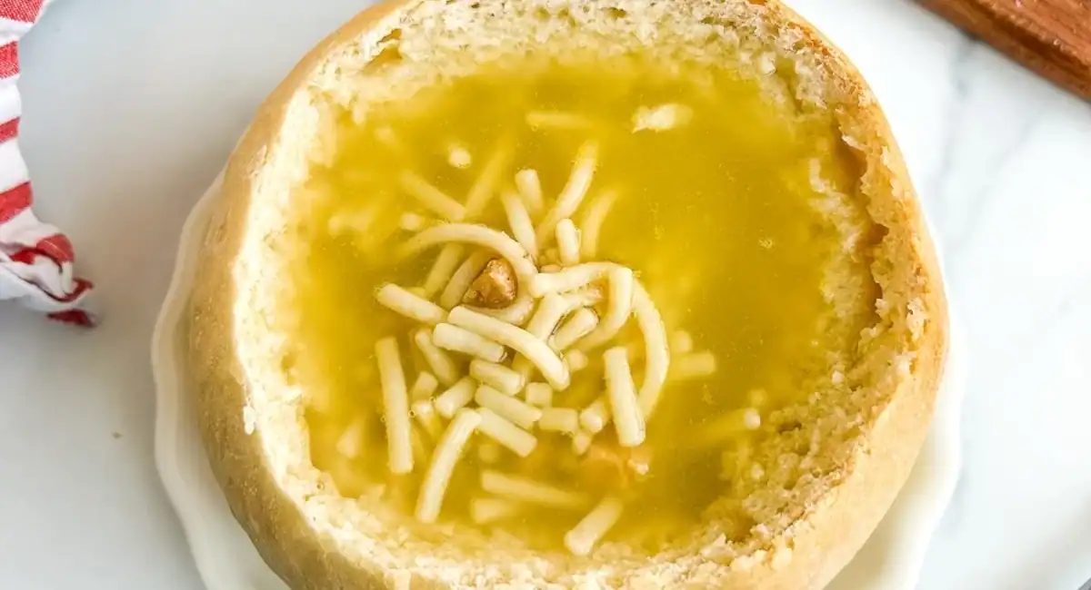 Overhead image of sourdough bread bowl with noodle soup.