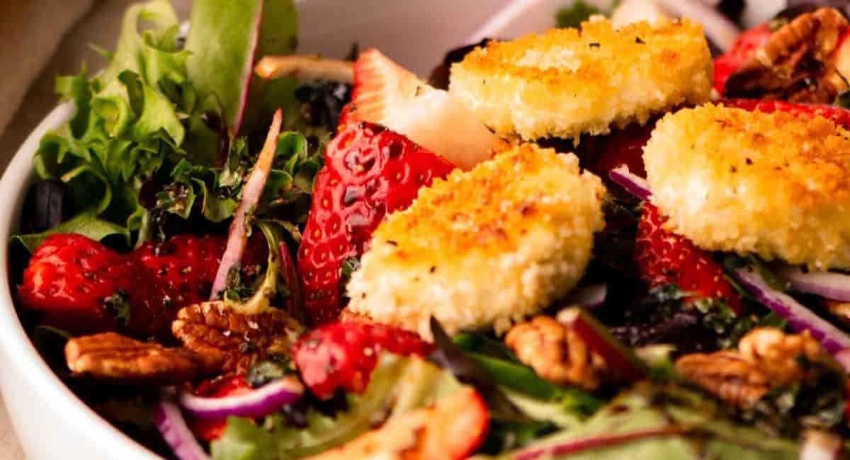 Up close image of strawberry salad with warm goat cheese croutons.