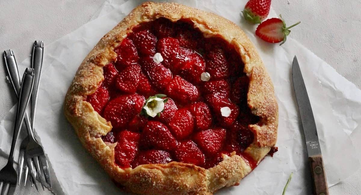 Overhead image of strawberry galette with garnish.