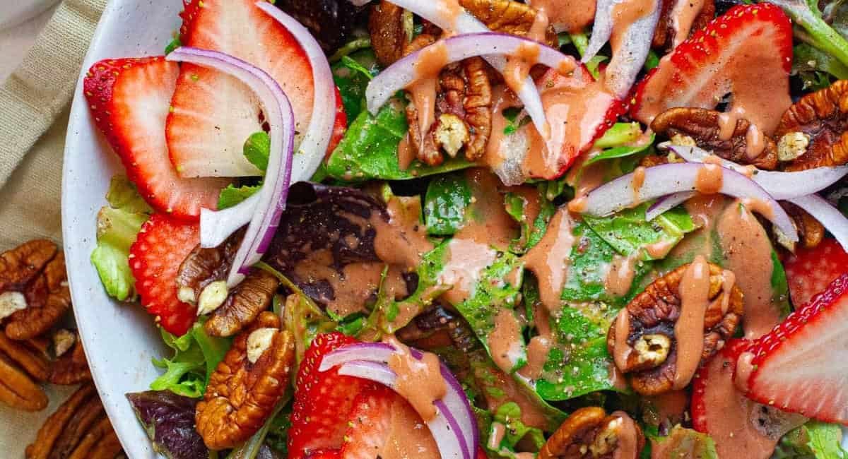 Overhead image of strawberry pecan salad with strawberry vinaigrette.