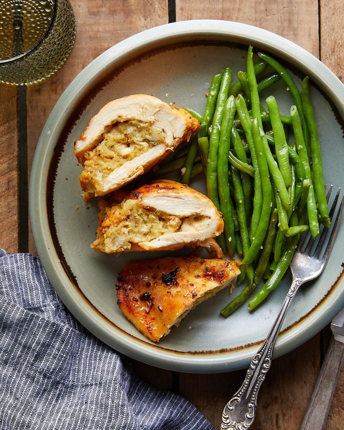 Overhead image of stuffing stuffed chicken breasts with green beans side.