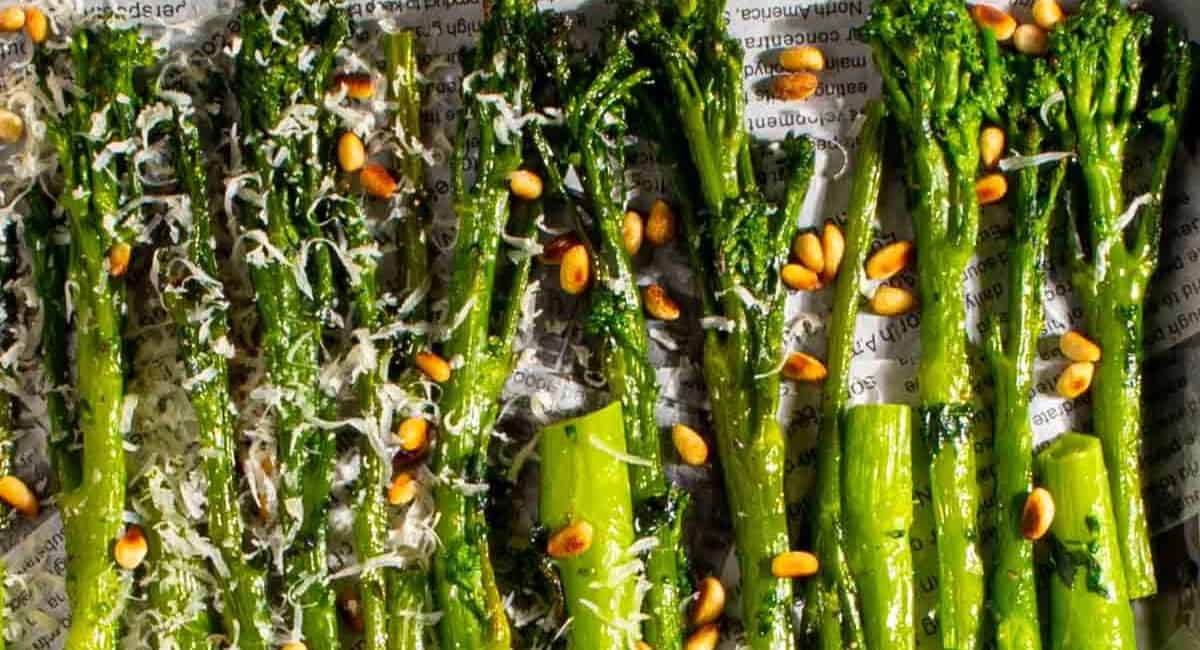 Overhead image of tender stem broccoli with parmesan and pine nuts.