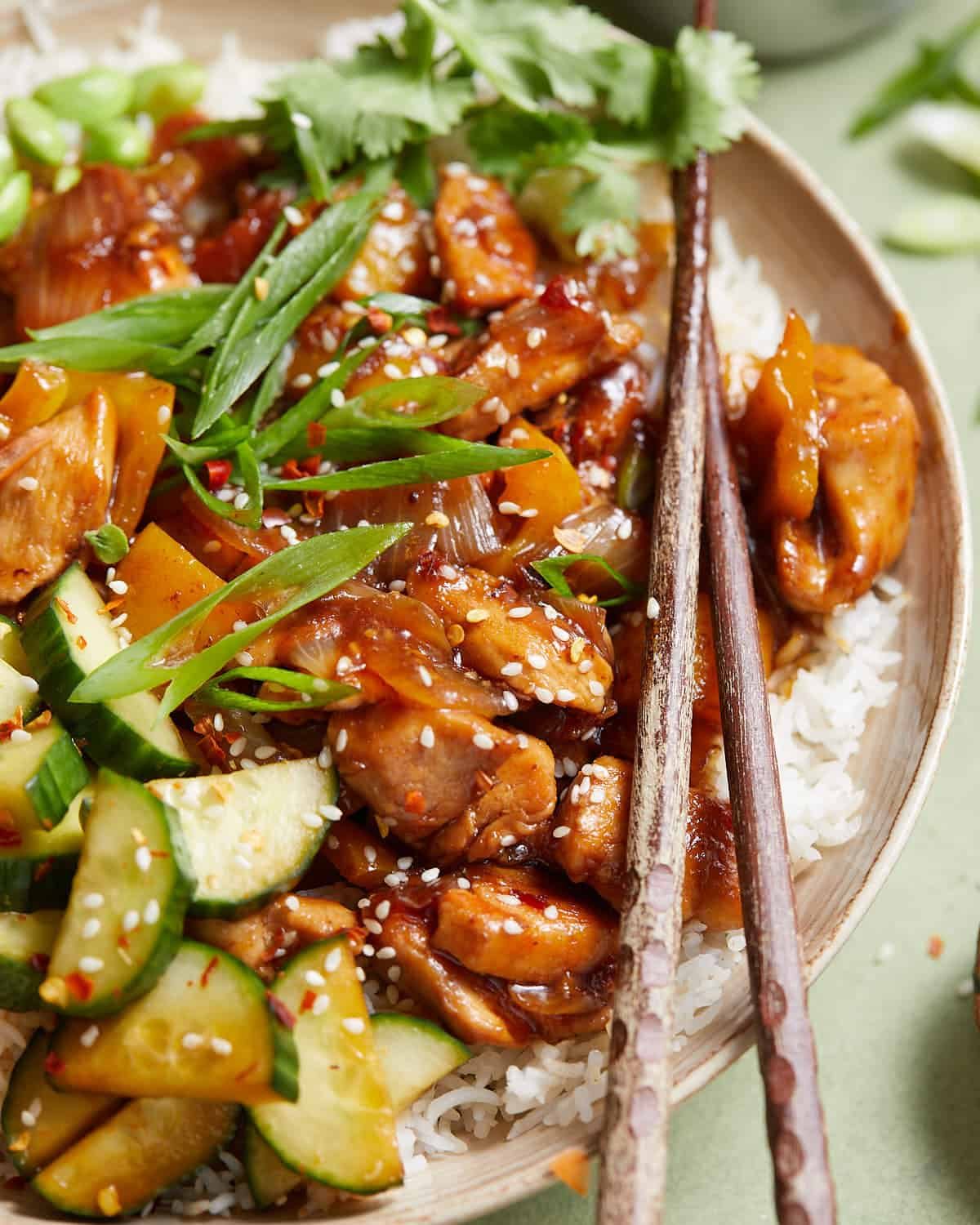 Up close image of teriyaki chicken bowl with chopsticks.