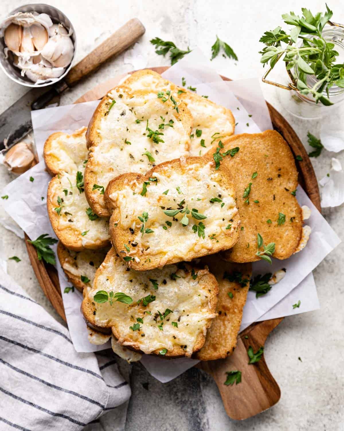 Texas toast garlic bread on a wood plate.